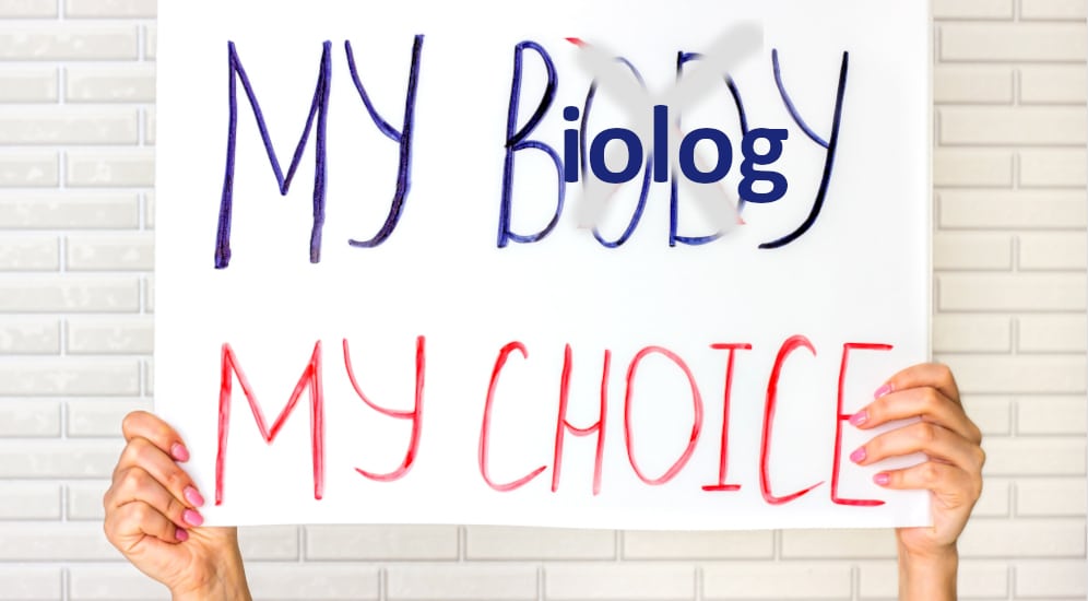 femme tenant un panneau où il est écrit my body (barré) pour mettre my biology, my choice